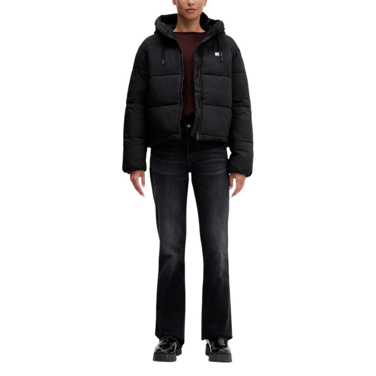 Outfit completo con giubbotto Tommy Hilfiger Jeans Donna nero, abbinato a jeans scuri e scarpe nere. Giacca puffer perfetta per l'inverno.